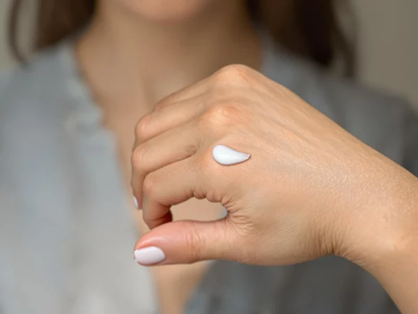 A hand with a small amount of cream applied, representing the application of CBD cream for topical use.
