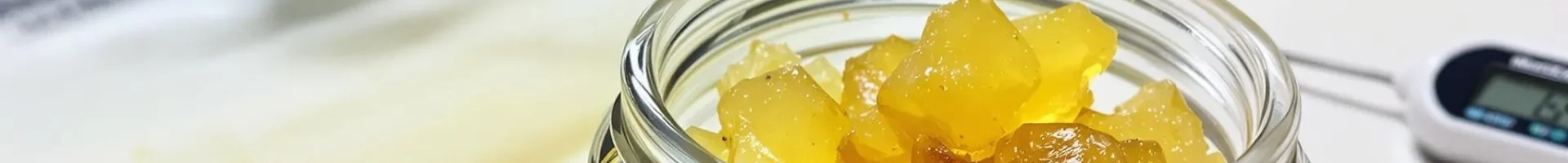 Golden live resin concentrate on a kitchen countertop with a baking sheet and thermometer nearby, ready for decarbing.