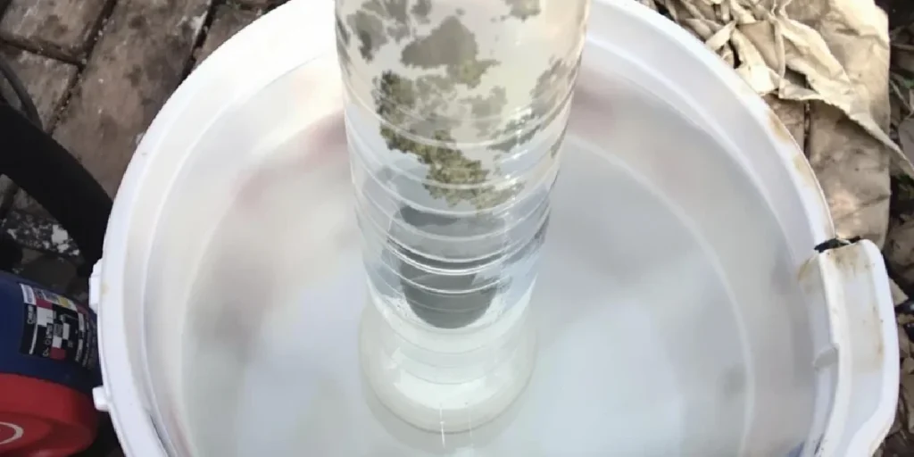 Homemade gravity bong using plastic bottle and water container.