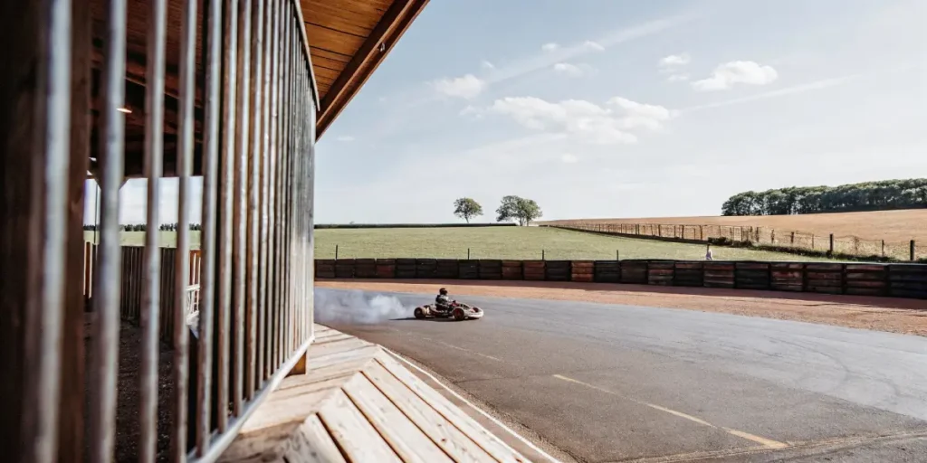 go-kart speeding on a rural racetrack with scenic countryside in the background