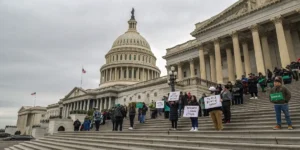 Supporters of NORML marijuana reform holding signs outside a government building.