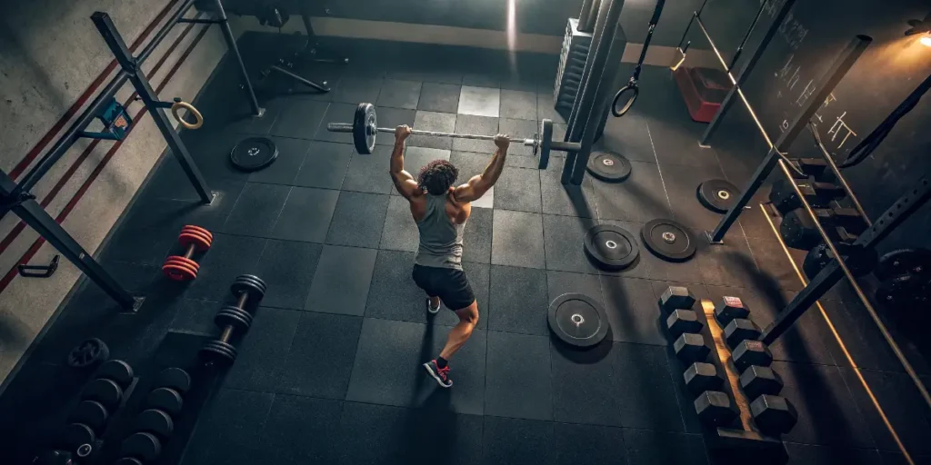 Athlete lifting weights in a gym, illustrating how exercise affects THC stored in fat cells.