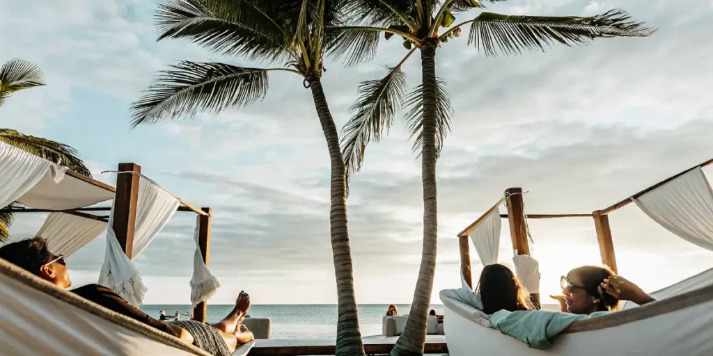Guests lounging in hammocks facing the ocean at a tropical beachfront resort